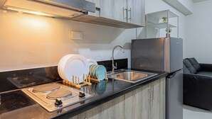 A modern kitchen with stainless steel appliances, wooden cabinets, and a built-in dishwasher. - Family 2BR at MOA Sea Residence Sleeps 5 (Pasay City)