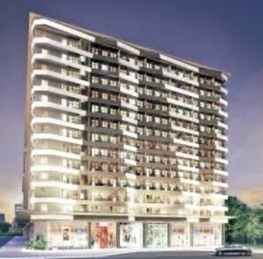 Un hôtel à plusieurs étages doté de balcons, d’un espace commercial au rez-de-chaussée et d’une architecture moderne.