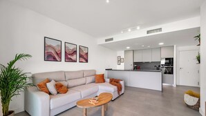 Una sala de estar moderna con sofá, mesa de centro y una obra de arte en la pared.