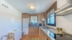 A modern kitchen with a built-in stove, a sink, and wooden cabinets. - LXR Hollywood Hills 2-Bedroom: Stunning Views (Mijas)