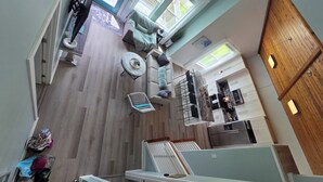 Un interior moderno con techos altos, comedor, cocina y zona de estar con vistas.