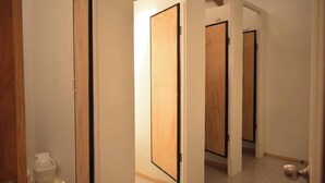 Pasillo con puertas de madera y un cesto de basura.