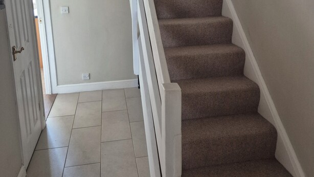 A staircase with carpeted steps and white railings, leading to an upper floor. - Delightful Ipswich Town 3 Bed House awaits you. (Ipswich)
