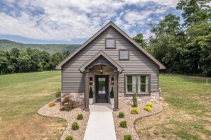 A two-story house with a stone foundation, a front porch, and a well-maintained lawn. - Elm View Cottage in Newburg. A cozy 2 bedroom getaway. (Newburg)