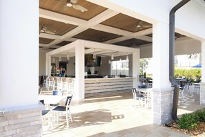 Een terras buiten met een bar en zitplaatsen.