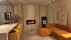 Ein modernes Wohnzimmer mit einer Couch, einem Fernseher und einer Bar.