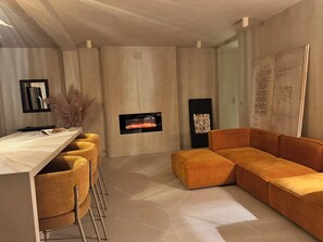 Ein modernes Wohnzimmer mit einer Couch, einem Fernseher und einer Bar.