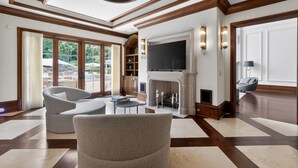 A spacious living room with a fireplace, large windows, and a modern fireplace screen. - Marietta Mansion in Marietta (Marietta)
