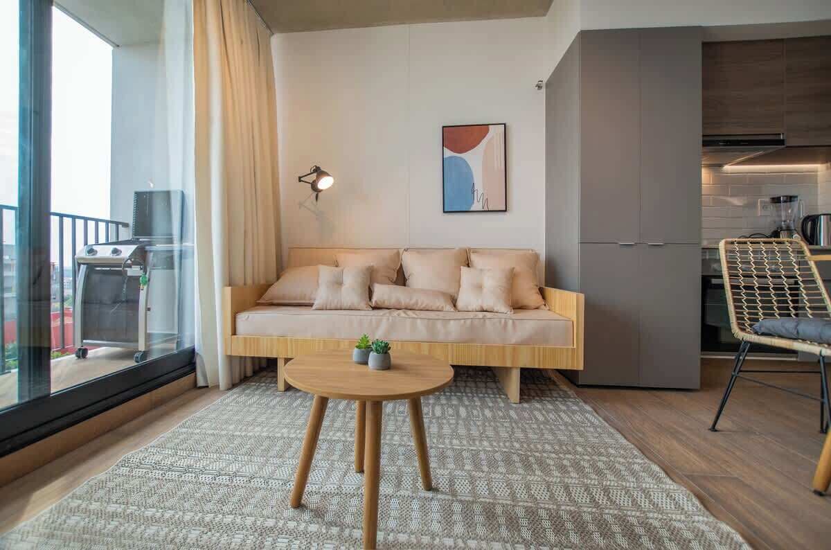 Ein modernes Wohnzimmer mit einer Couch, einem Tisch und einem Sessel.