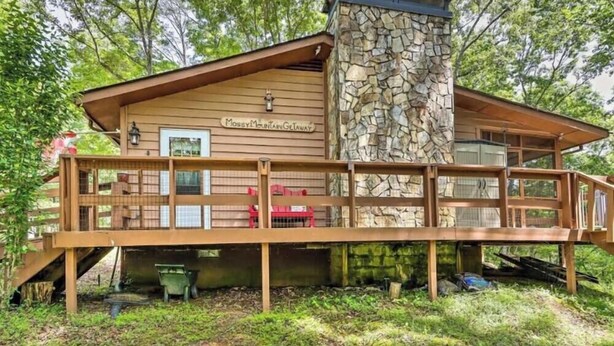 Eine Holzhütte mit einem Steinkamin, einer Holzdiele und einem Schild mit der Aufschrift 'Mosby Mountain Getaway'.