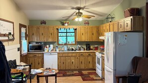 Eine Küche mit Holzausstattung, Deckenventilator und Kühlschrank.
