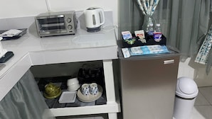 Pieni keittiönurkkaus, jossa on leivänpaahdin, vedenkeitin ja kahvinkeitin, pieni jääkaappi, jossa on myös vesihana, sekä roskakori.