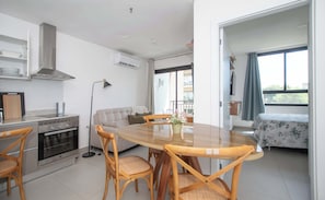 Eine moderne Küche mit Essbereich, einer Couch und einem Balkon mit Blick.