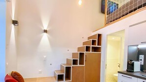 Un interior moderno con un banco de madera, una escalera y una zona de cocina.