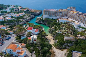 Ein Küstenhotel mit mehreren Gebäuden, einem Strand und einer felsigen Küstenlinie.