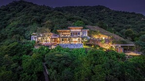 A modern house with a swimming pool, surrounded by lush greenery and hills. - Ocean view · infinity pool · fully equipped private spa (Playa Grande)