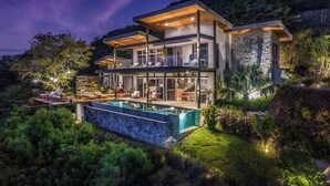A modern two-story house with a swimming pool, surrounded by lush greenery. - Ocean view · infinity pool · fully equipped private spa (Playa Grande)