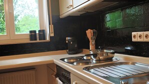 Une cuisine équipée d’une cuisinière, d’une machine à café et de théières.