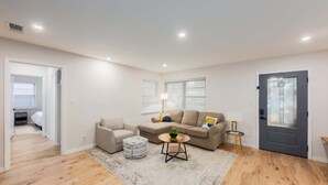 Un salon moderne avec un canapé, un fauteuil et une petite table sur laquelle est posée une plante.