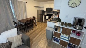 Un espacio habitable compacto con kitchenette, comedor y zona de estar.