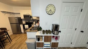 Una cocina equipada con microondas, horno, fregadero y cafetera.