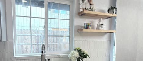 Eine Küche mit Spüle, Arbeitsplatte, Schränken und einem Fenster.