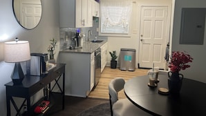 A compact kitchen with a dining area, a small refrigerator, and a coffee machine. - The Buckhead Luxe – by Vivo (Atlanta)