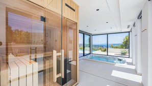 A modern spa room with a glass enclosure, a hot tub, and a view of the landscape. - View villas collection - 5 star Villa Blue horizon, pure luxury and comfort (Vinišće)