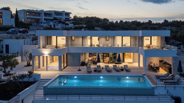 A modern two-story house with a swimming pool, outdoor seating, and a view of the surrounding landscape. - View villas collection - 5 star Villa Blue horizon, pure luxury and comfort (Vinišće)