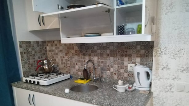 A kitchen with a gas stove, sink, and a kettle. - Apartment in Side Evrenseki, Hotel Comfort Home Feel (Manavgat)
