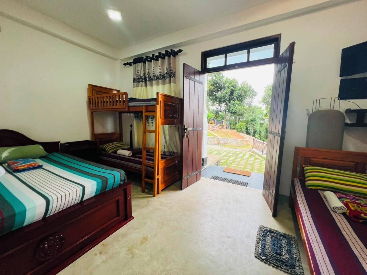 A bedroom with a bunk bed, a single bed, and a large window.