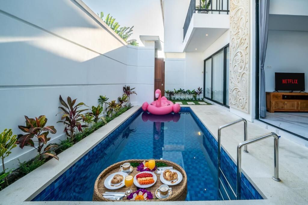 Una piscina con un flotador de flamenco rosa, una bandeja de comida y el logo de Netflix.