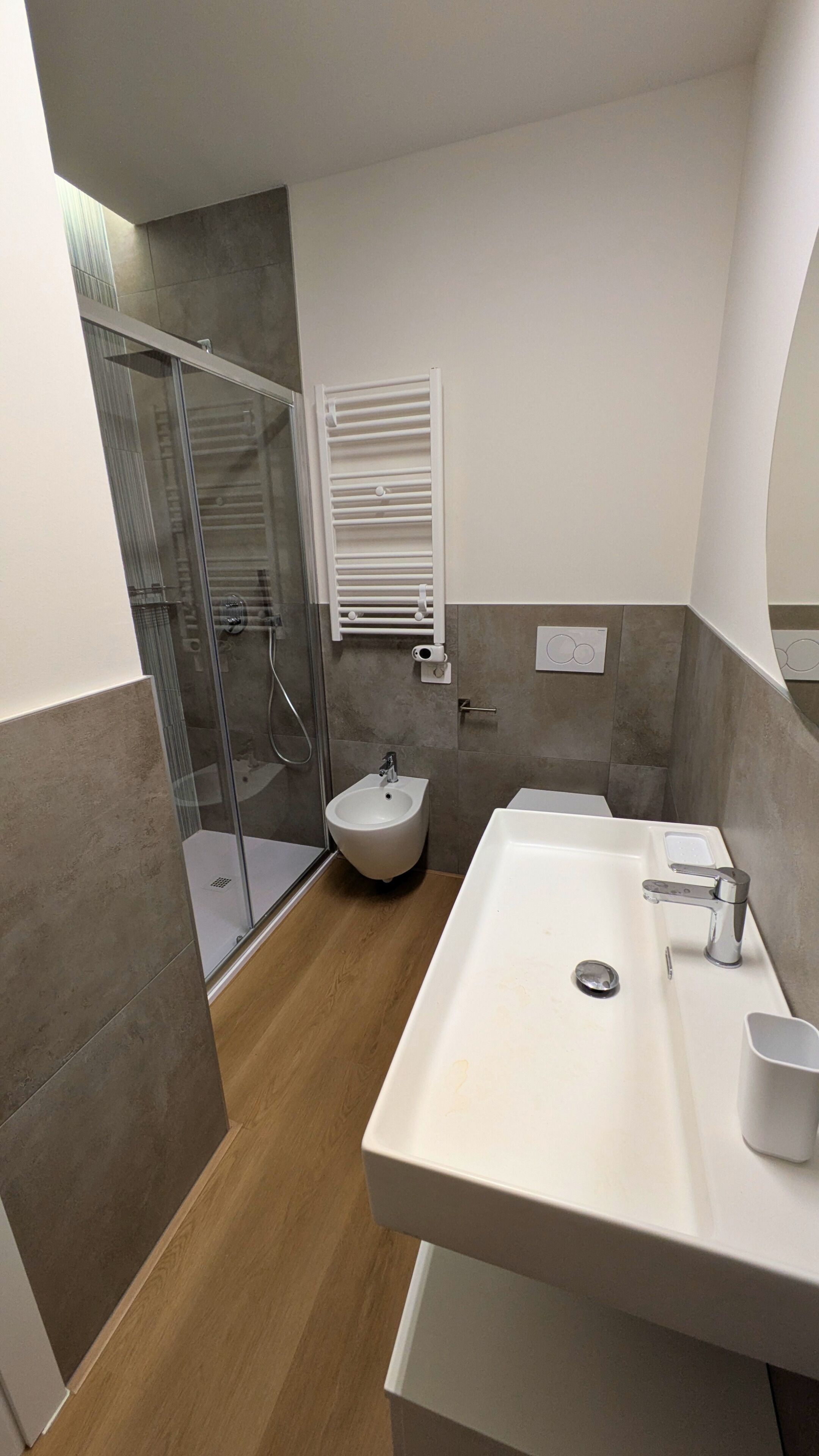 Un baño moderno con ducha, bidé y un lavamanos grande.