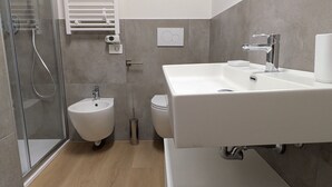 A modern bathroom with a bidet, a toilet, a shower, and a large mirror. - Sfreg Suites Magenta - camere e B&B (Magenta)
