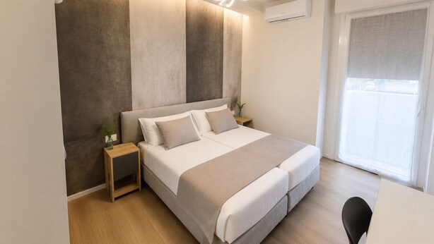 A modern bedroom with a bed, bedside tables, an air conditioning unit, and a view of the outside. - Sfreg Suites Magenta - camere e B&B (Magenta)