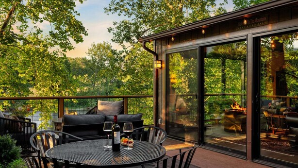Une terrasse extérieure avec une table ronde, des chaises et un canapé.