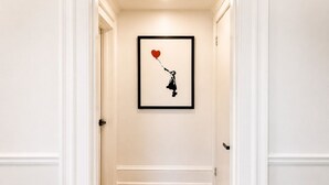 En hall med ett inramat konstverk som föreställer en person som håller en hjärtformad ballong.
