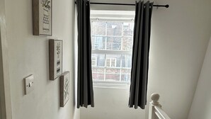 A room with a window, a bench, and a white railing. - House Sleeps 22 With Wifi (London)