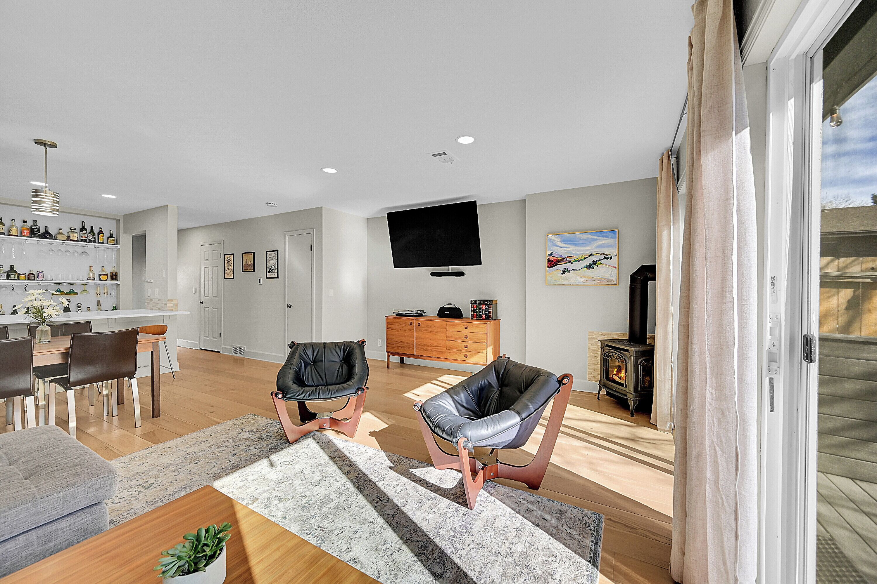 A modern living room with a fireplace, a television, and a dining area.