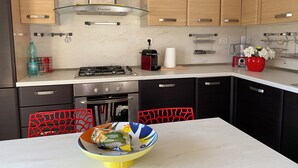 A modern kitchen with a gas stove, oven, and stainless steel cabinets. - CASA SARDAIGNE—3 bedrooms, 6 beds—house with a separate studio and a garden. (Sarroch)