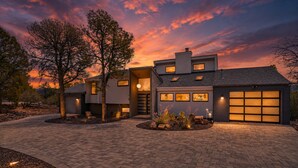 Ein modernes, zweistöckiges Haus mit Garage, Auffahrt und einem angelegten Vorgarten.