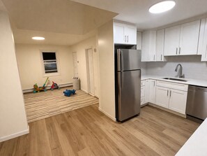 Una cucina moderna con mobili bianchi, un frigorifero in acciaio inossidabile e una lavastoviglie.