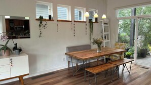 A modern kitchen with wooden cabinets, a dining table with benches, pendant lights, and a view through a large window. - Beautiful pet-friendly, 4-bedroom, 3.5 bath house in North Boulder (Boulder)