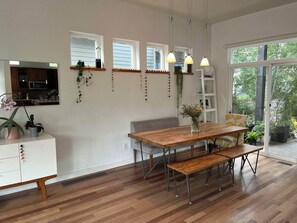 A modern kitchen with wooden cabinets, a dining table with benches, pendant lights, and a view through a large window. - Beautiful pet-friendly, 4-bedroom, 3.5 bath house in North Boulder (Boulder)