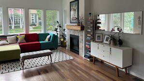 A living room with a fireplace, a sofa, a bench, and a bookshelf. - Beautiful pet-friendly, 4-bedroom, 3.5 bath house in North Boulder (Boulder)