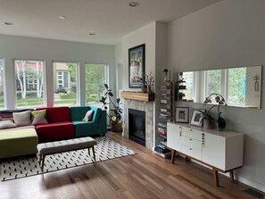 A living room with a fireplace, a sofa, a bench, and a bookshelf. - Beautiful pet-friendly, 4-bedroom, 3.5 bath house in North Boulder (Boulder)
