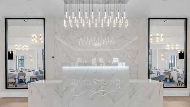 A reception desk with a marble top and a hanging light fixture. - Putterly Perfect 3rd Floor Golf Front Condo (Bradenton)