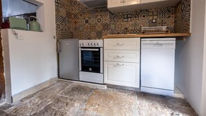 A compact kitchen with a built-in oven, a dishwasher, and a patterned backsplash. - Le Barrinal - MAS-SAINT-CHELY (MAS-SAINT-CHELY)