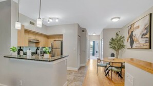 A modern kitchen with granite countertops, stainless steel appliances, and pendant lighting. - Cozy retreat minutes away from FIFA World Cup (Atlanta)