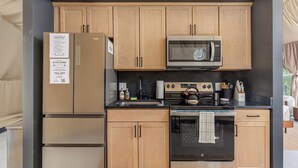 Cocina compacta con refrigerador, microondas, estufa y horno.
